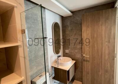 Modern bathroom with wooden accents and natural stone tiles