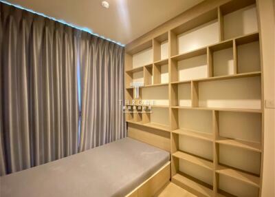 Modern bedroom interior with built-in shelving and bench seating by the window