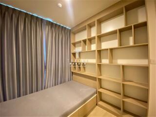 Modern bedroom interior with built-in shelving and bench seating by the window