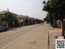 Paved street in a residential neighborhood with houses and parked cars