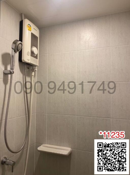 Wall-mounted water heater with shower in a tiled bathroom