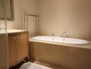 Elegant bathroom with a large bathtub, towel warmer, and wooden vanity cabinet