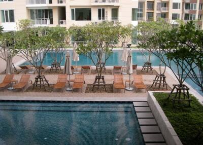 Swimming pool and lounging area in a residential complex courtyard
