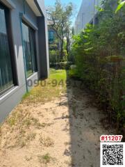 Pathway alongside a modern building with greenery