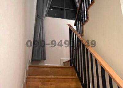 Interior staircase with wooden steps and black balusters