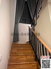 Interior staircase with wooden steps and black balusters