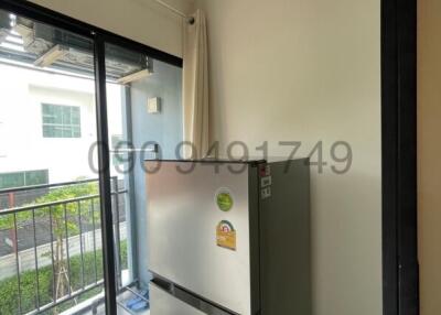 Compact kitchen area with large window and refrigerator