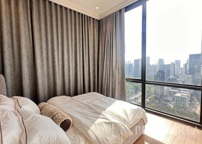 Spacious bedroom with a large window offering city views
