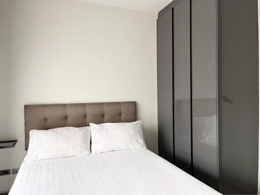 Modern bedroom with a large bed and a sleek wardrobe