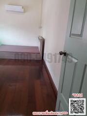 Simple bedroom interior with wooden flooring and white walls