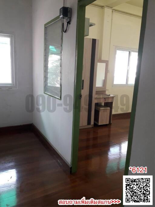 Spacious bedroom with wooden floor and natural light