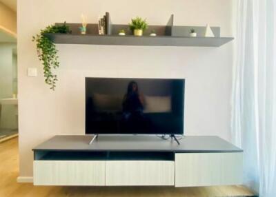 Modern living room with wall-mounted TV and floating shelves