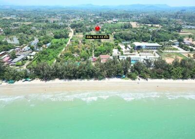 Aerial view of a coastal real estate property with surrounding greenery