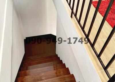 Wooden staircase with black metal balusters leading downstairs