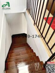 Wooden staircase with black metal balusters leading downstairs