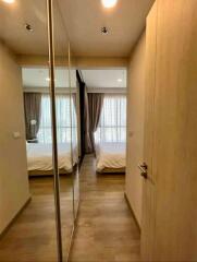 View into a cozy bedroom with wooden wardrobe and mirror