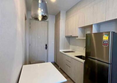 Compact modern kitchen with stainless steel appliances and a small dining area