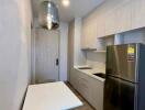 Compact modern kitchen with stainless steel appliances and a small dining area
