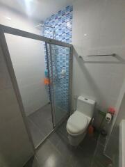 Modern bathroom with glass shower enclosure and blue tile accents