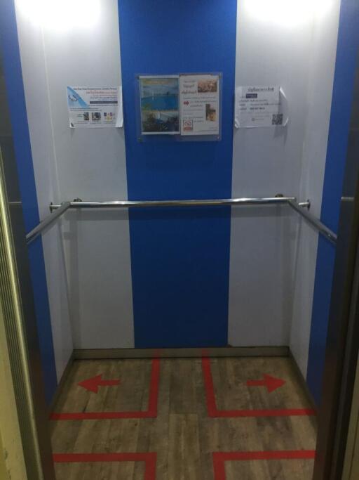 Interior of a modern elevator with informational posters on the wall