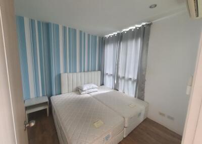 Cozy bedroom with twin beds and striped blue curtains