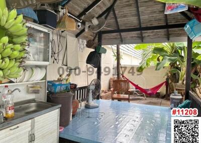 Covered outdoor space with kitchen sink and relaxation spot