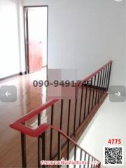 Spacious hallway with wooden flooring and red railing