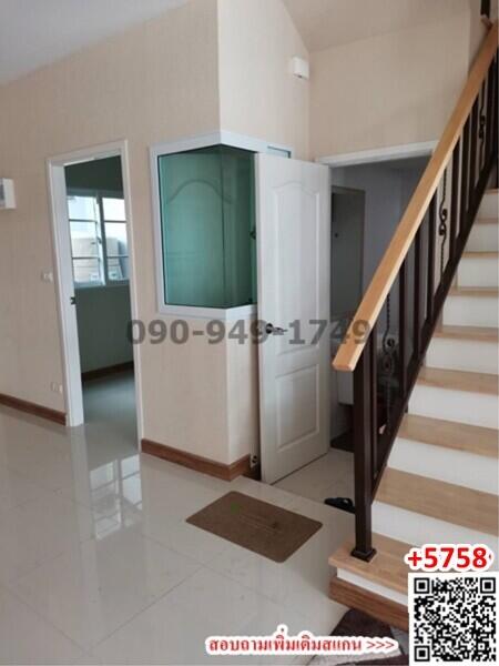 Bright entryway space with tiled flooring, wooden staircase, and access to rooms