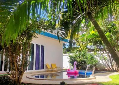Tropical backyard with swimming pool and lush greenery