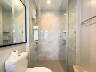 Modern bathroom interior with glass shower and white ceramics