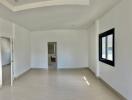 Spacious and bright unfurnished living room with laminate flooring and large window