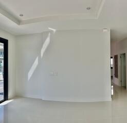 Spacious and well-lit empty living room with white walls and tiled flooring