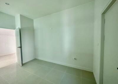 Empty bedroom with tiled floor and natural light