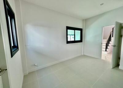 Spacious empty bedroom with tiled flooring and natural light