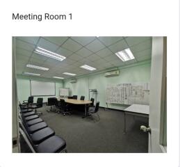 Spacious meeting room with a large table, chairs, and presentation boards