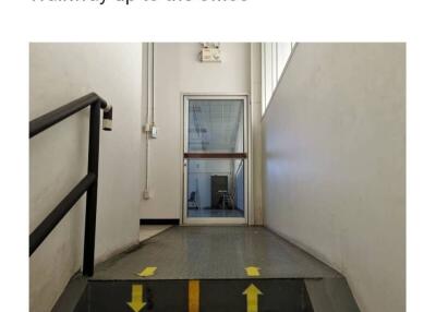 Office hallway with directional arrows on the floor leading to a glass door