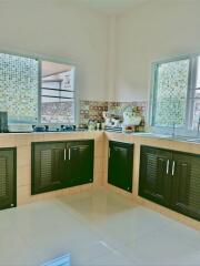 Bright kitchen with tile flooring and mosaic window details