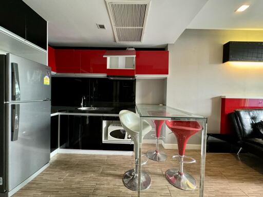 Modern kitchen with red and black cabinetry and a breakfast bar