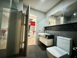 Modern bathroom interior with a glimpse into an adjoining kitchen area