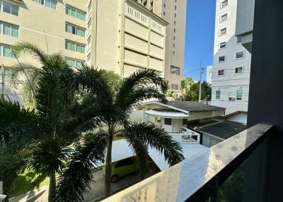 View from the balcony of a city apartment showing surrounding buildings and greenery