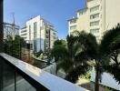 Balcony with a view of surrounding buildings and greenery