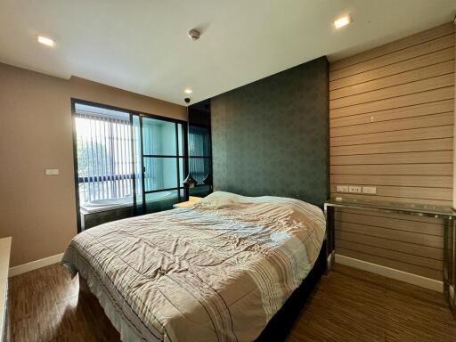 Spacious bedroom with queen-sized bed and large windows