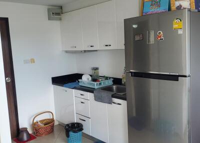 Modern kitchen with white cabinetry and stainless steel refrigerator