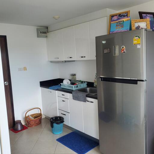 Modern kitchen with white cabinetry and stainless steel refrigerator