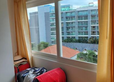 Bedroom with a large window overlooking neighboring buildings