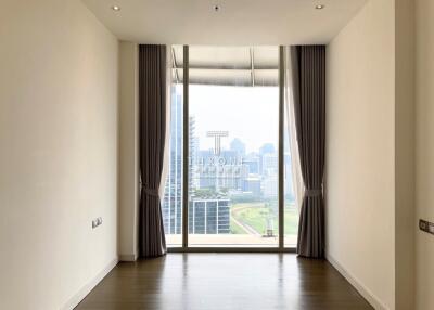 Spacious bedroom with large windows offering city views
