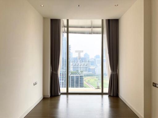 Spacious bedroom with large windows offering city views