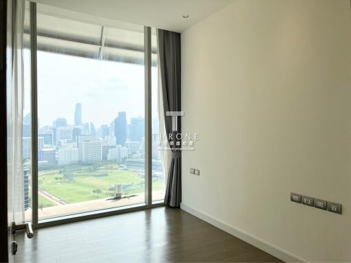 Bright bedroom with floor-to-ceiling window overlooking the city