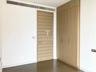Spacious modern interior with clean lines, featuring a wooden entrance door and matching wardrobe