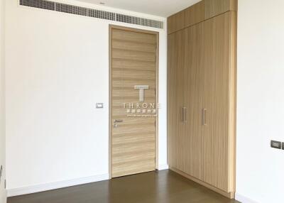 Modern interior design of a spacious building entrance with wooden door and wardrobe